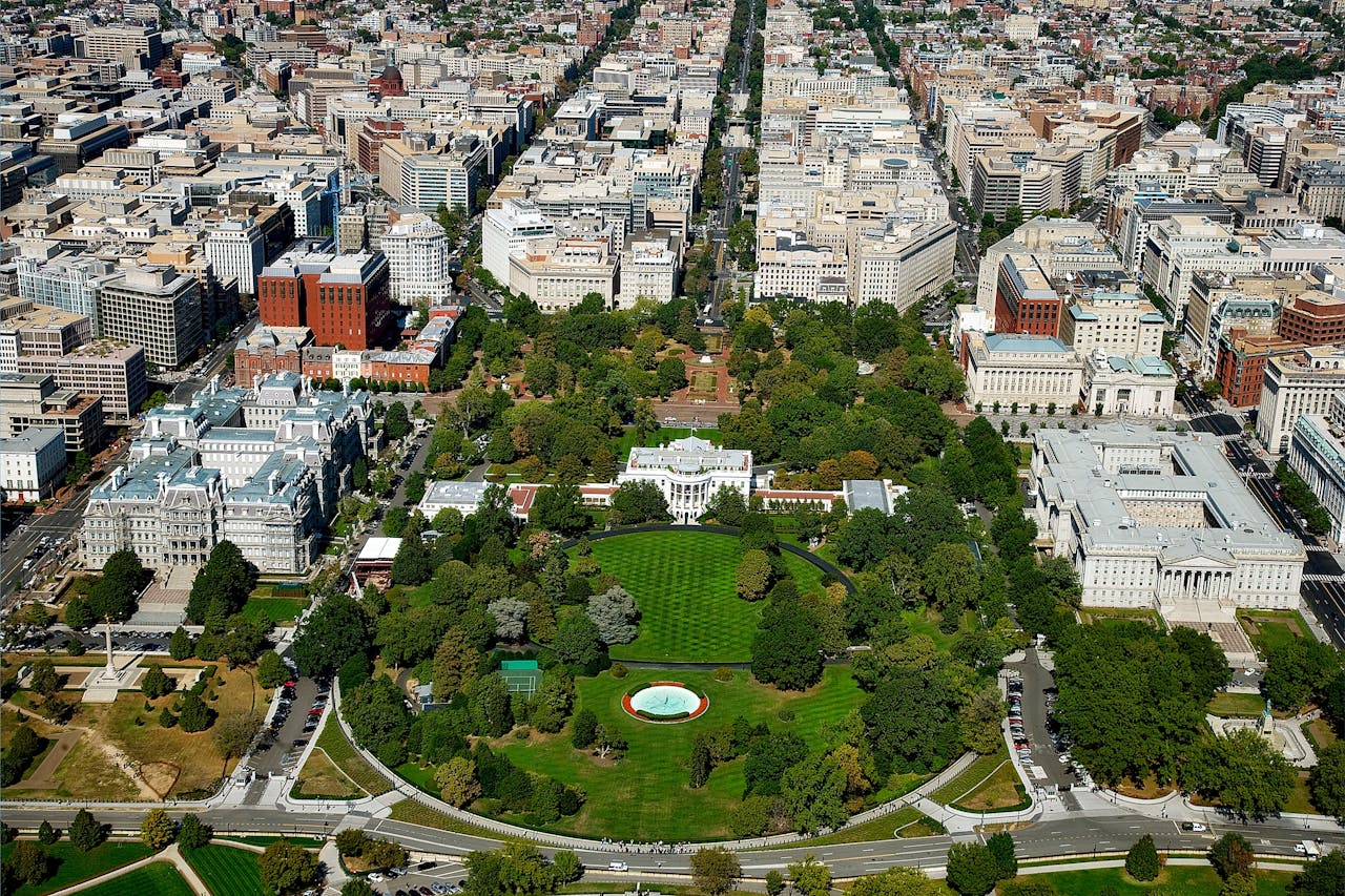 A stunning aerial view of The White House surrounded by downtown Washington D.C.s architecture and green spaces.